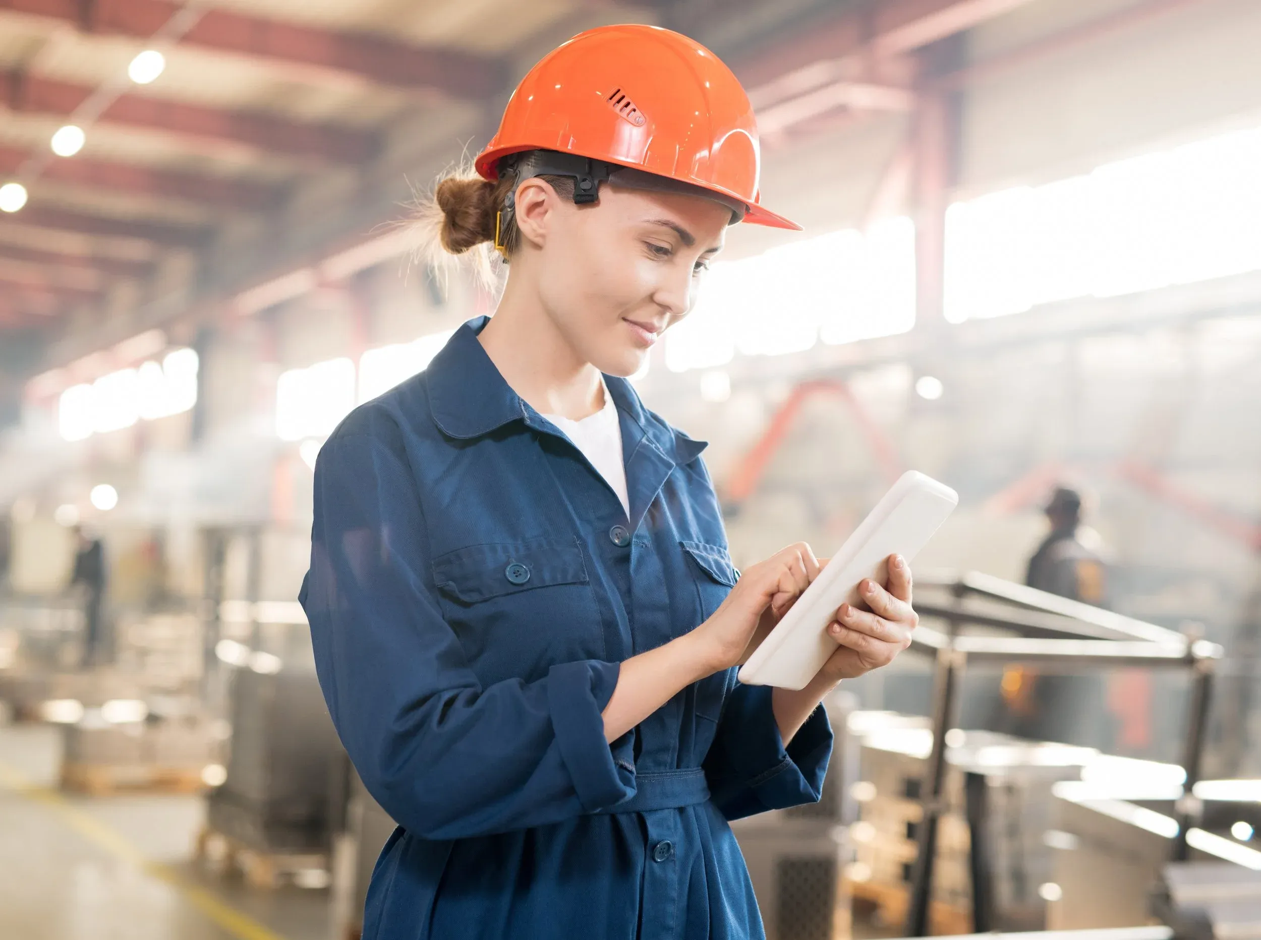 A production worker checks her data on a tablet on the factory floor